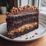 A decadent slice of chocolate caramel toffee crunch cake showing dark layers and caramel filling.