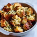 Close-up of golden brown bread cubes for crock pot stuffing, seasoned with herbs and onions.