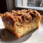 Close-up of a moist slice of french toast casserole topped with a thick cinnamon streusel.