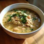 Close-up of a bowl of creamy instant pot white chicken chili topped with shredded chicken and fresh cilantro.