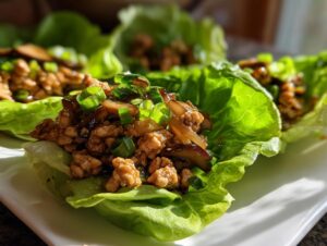 Close-up of a fresh chicken lettuce wraps serving, filled with savory ground chicken and topped with green onions.