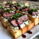 Close-up of perfectly cooked steak crostini topped with creamy cheese and chives, drizzled with balsamic glaze.