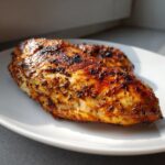 Close-up of a perfectly cooked, juicy chicken breast showing a caramelized crust from the amazing chicken marinade.