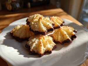 A plate of golden Italian butter cookies with textured tops, dipped in dark chocolate on the bottom.