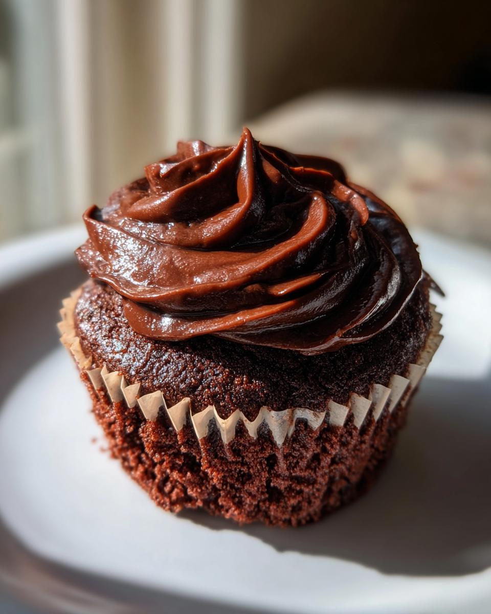 Close-up of a decadent chocolate cupcake with rich, swirled chocolate frosting, perfect for raspberry chocolate cupcakes.