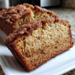 Close-up of a thick slice of snickerdoodle banana bread showing the moist crumb and cinnamon-sugar topping.