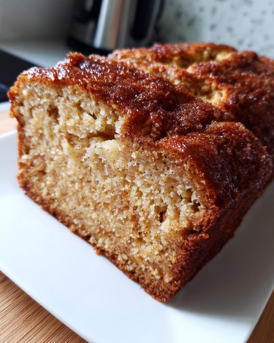 Close-up of a moist slice of snickerdoodle banana bread showing a rich, cinnamon-sugar crust.