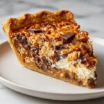 A decadent slice of texas trash pie showing layers of crust, cream cheese, chocolate chips, and a nutty caramel topping.