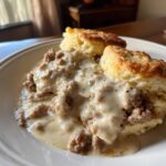 Close-up of fluffy biscuits smothered in creamy, peppery Sausage Gravy and Biscuits.