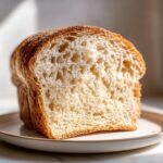 Close-up of a thick slice showing the open, soft crumb structure of the Soft Sourdough Sandwich Bread.